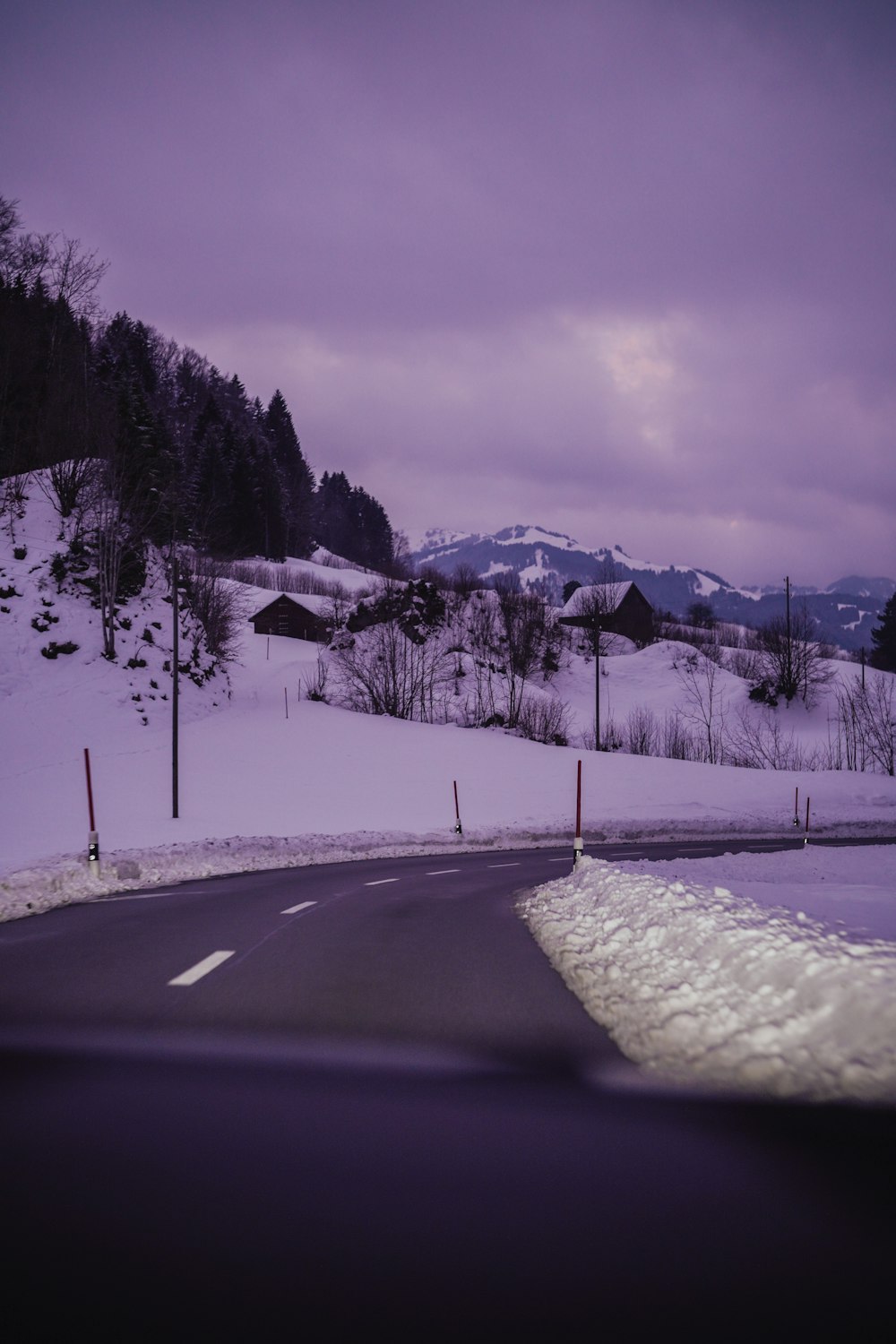 a snow covered road with a mountain in the background