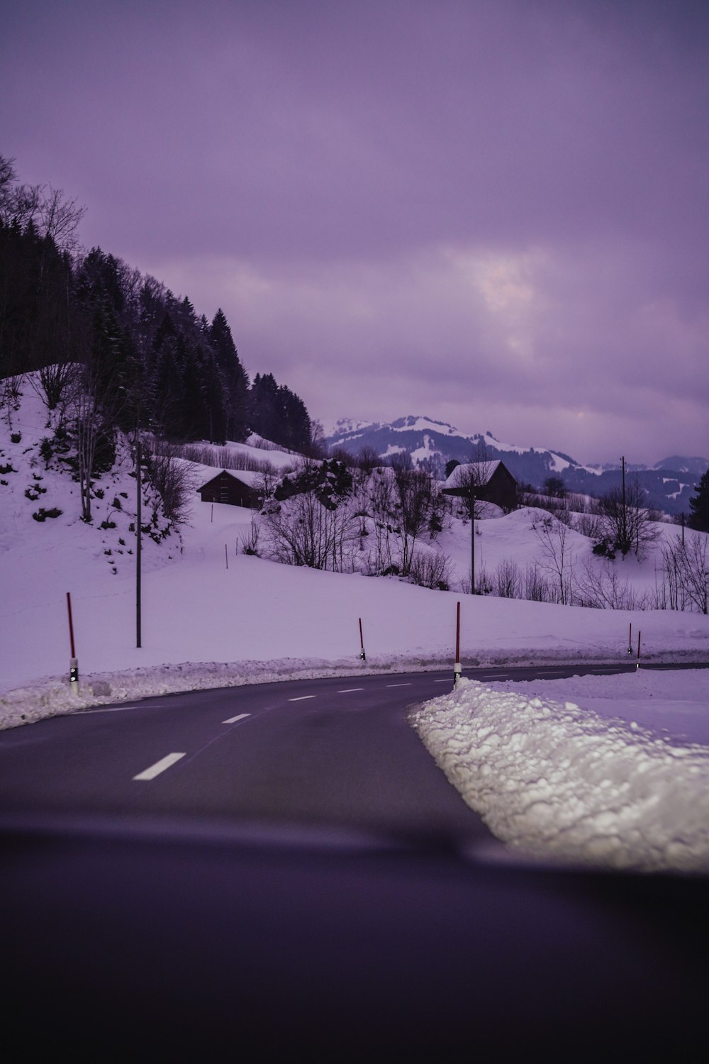 uma estrada coberta de neve com uma montanha ao fundo