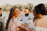 Snapshot of guests sharing laughter around a table at an outdoor celebration.