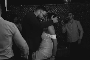 A photographer capturing key moments of a vibrant wedding reception with guests dancing.