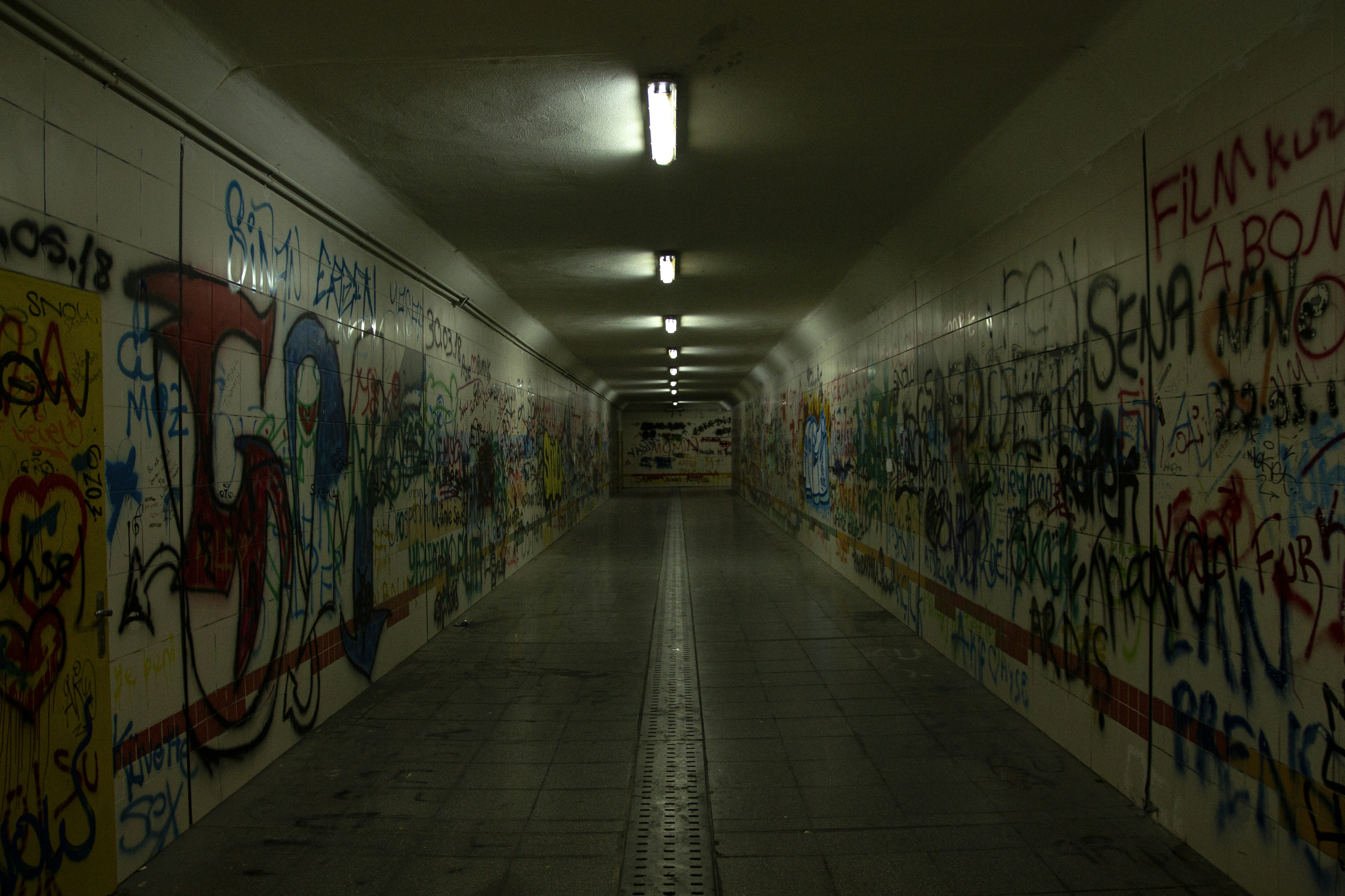 a long hallway with graffiti all over the walls