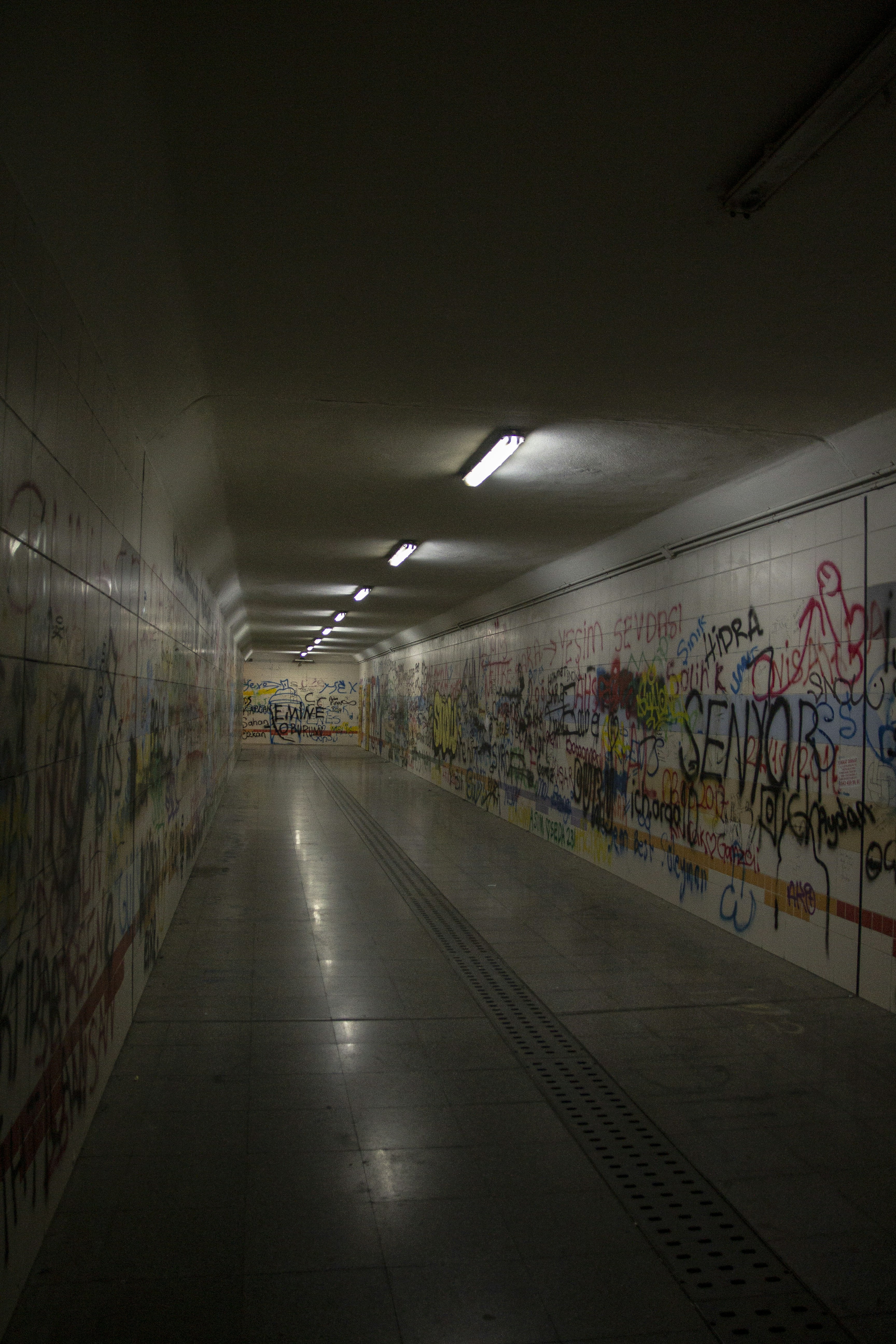 a long hallway with graffiti all over the walls