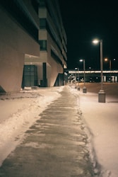 a sidewalk covered in snow next to a building