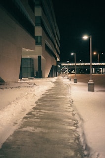 a sidewalk covered in snow next to a building