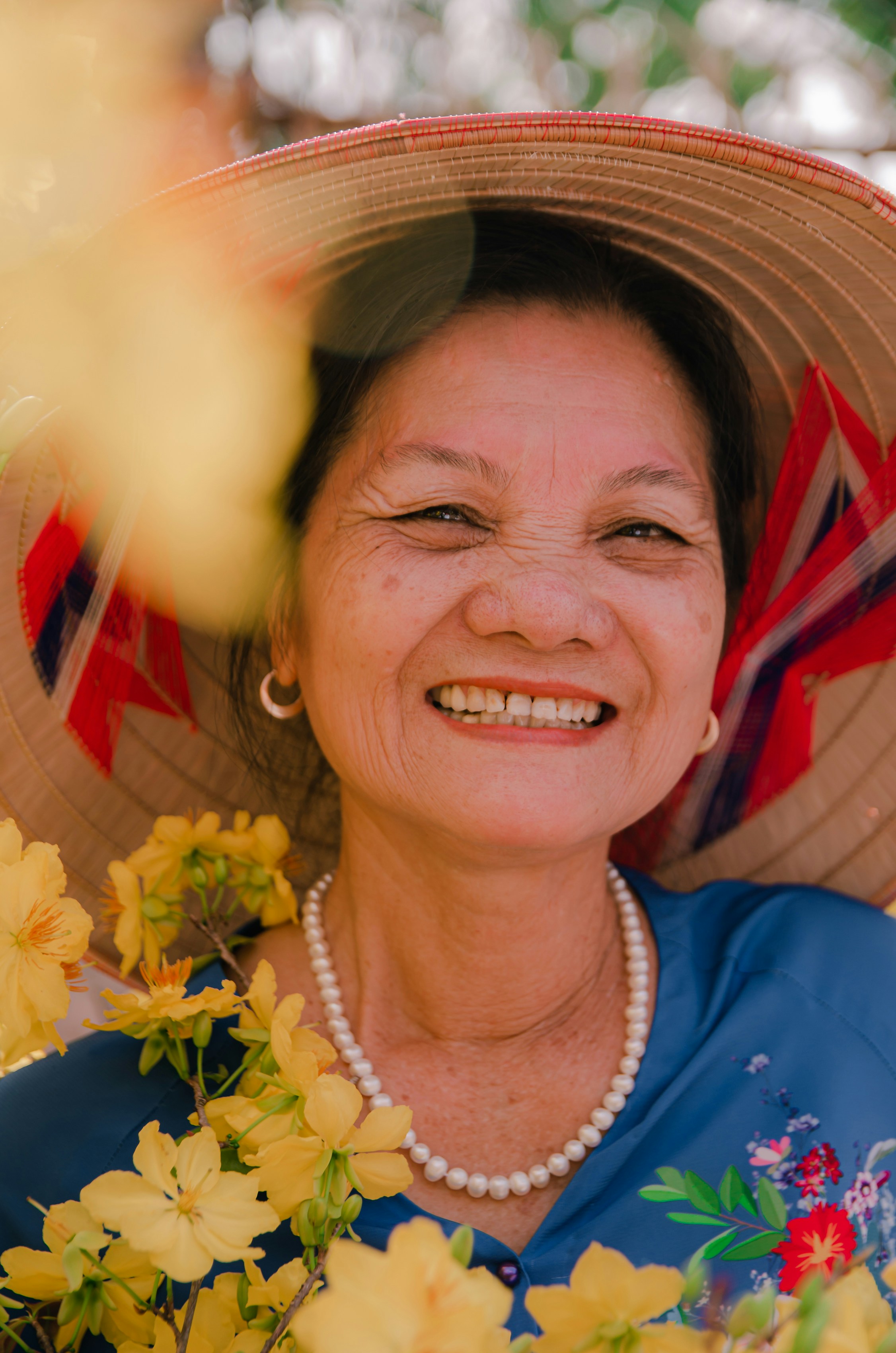 A woman wearing a hat with flowers around her neck photo Free Necklace Image on Unsplash