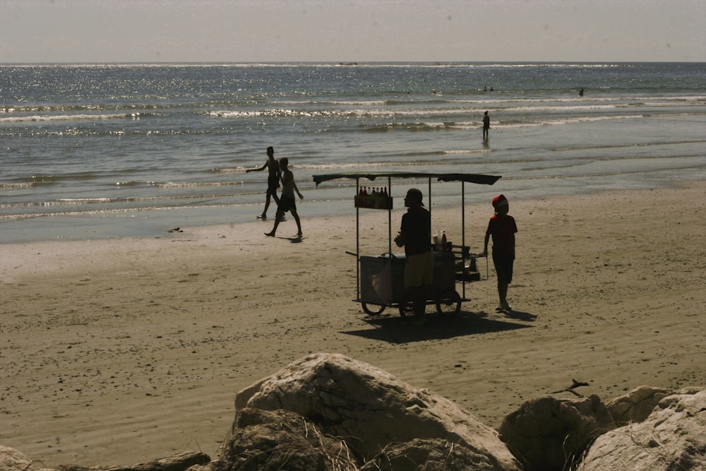 a group of people standing on top of a sandy beach