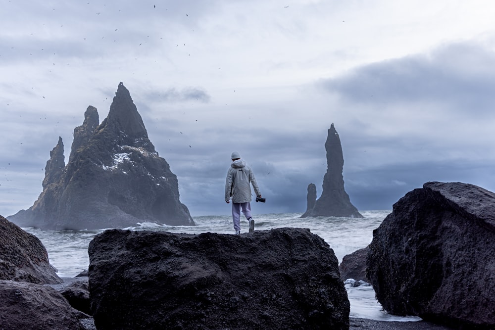 a rocky island in the middle of a body of water with Fitz Roy in the background