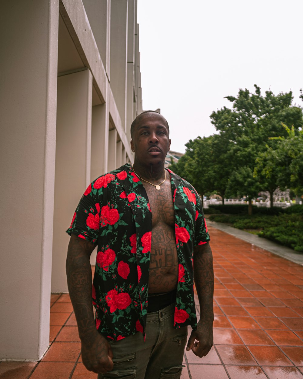 a man in a flowered shirt standing in front of a building