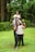 a man and two women holding a child on their shoulders