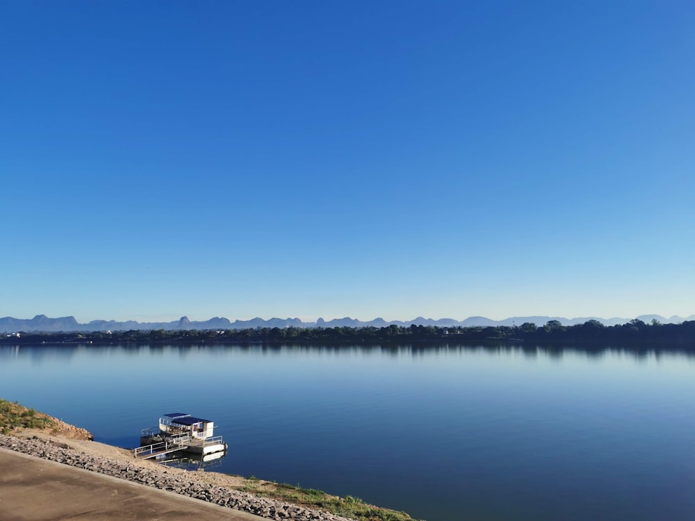 a boat is docked on the shore of a lake