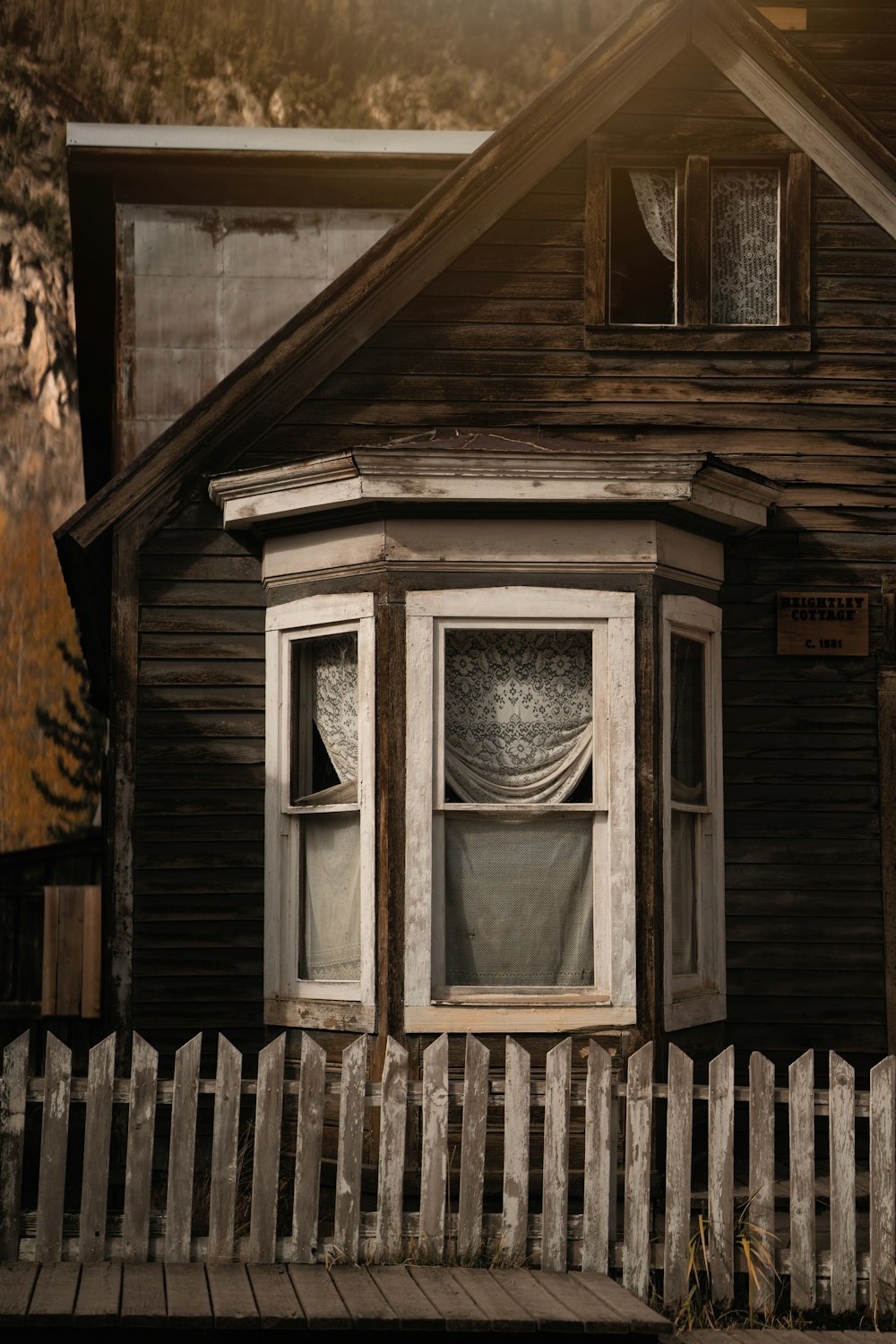 a wooden house with a white picket fence