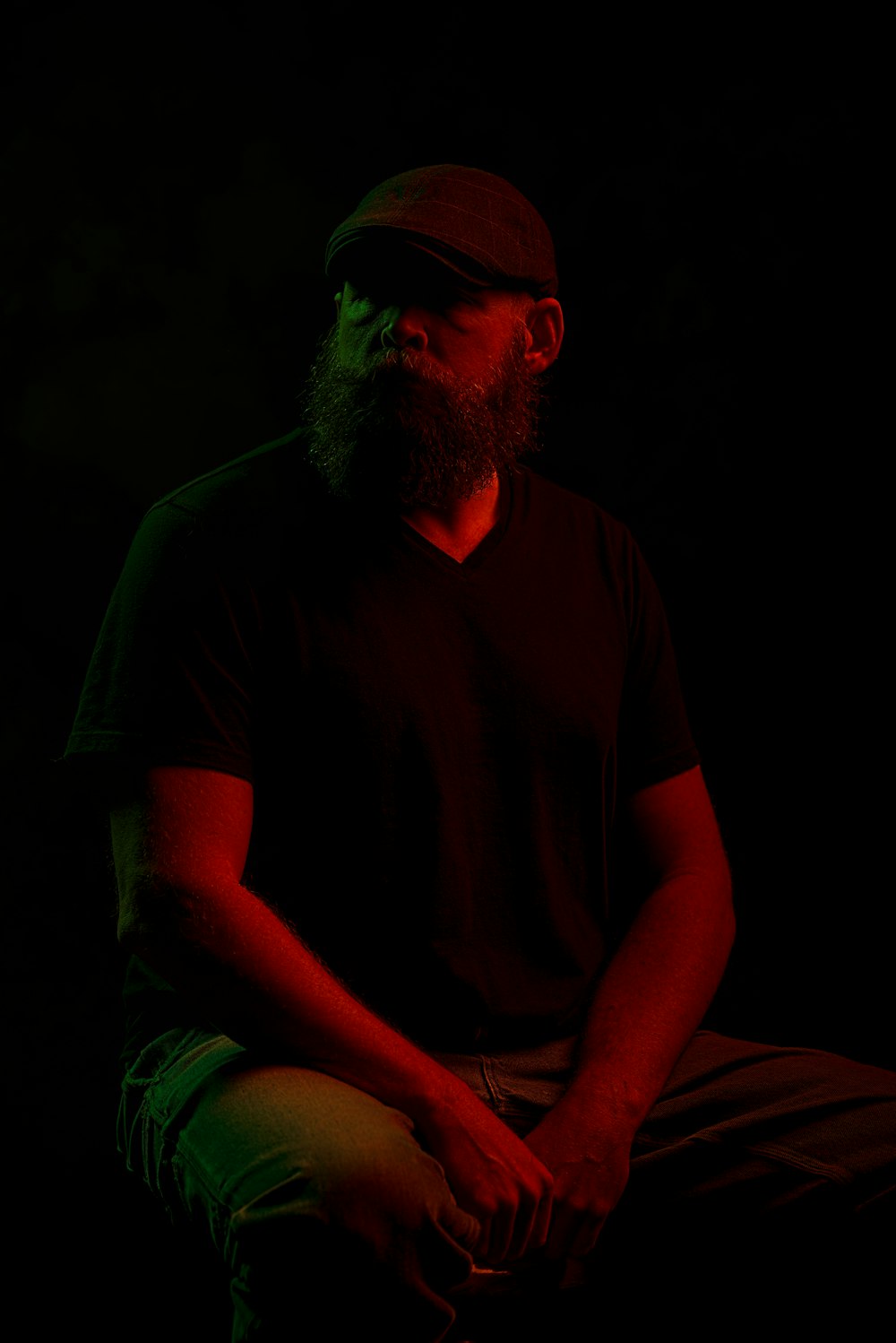 a man with a beard sitting in the dark