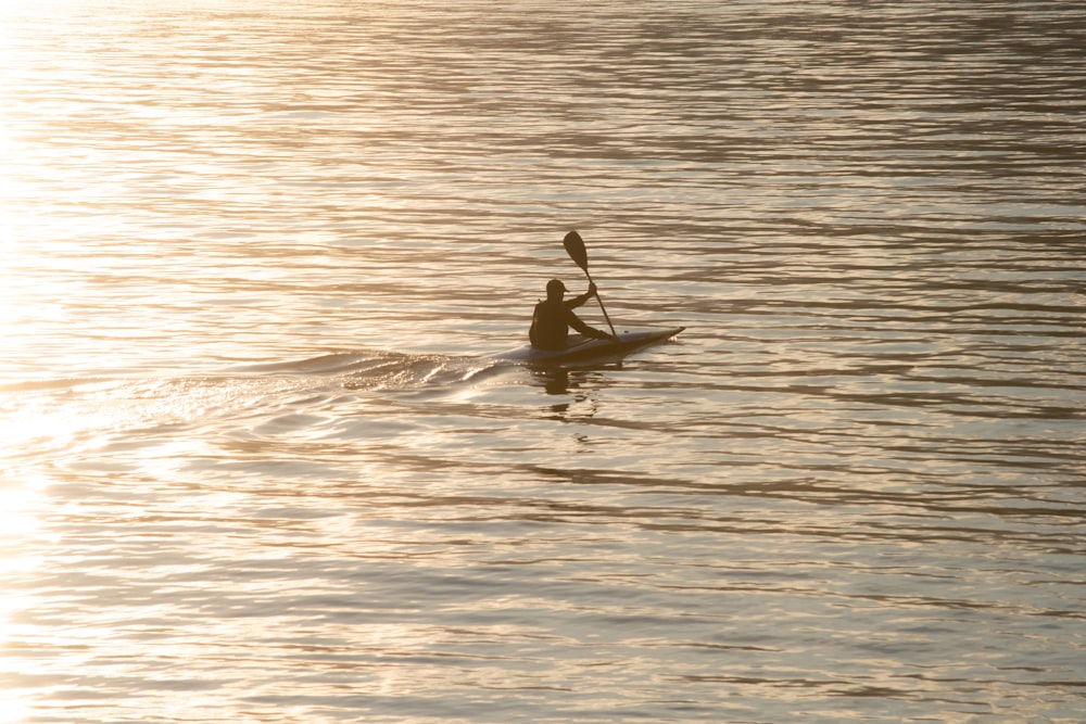 a person in a kayak paddling on the water