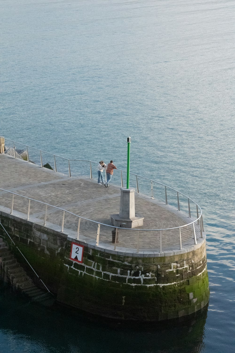 a couple of people standing on top of a pier