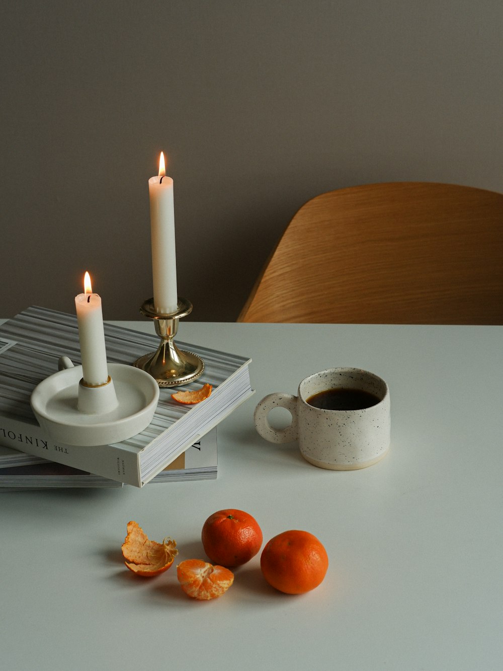 a table topped with a cup of coffee and two candles