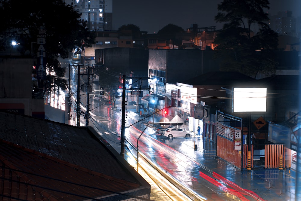 a city street at night with cars driving down it