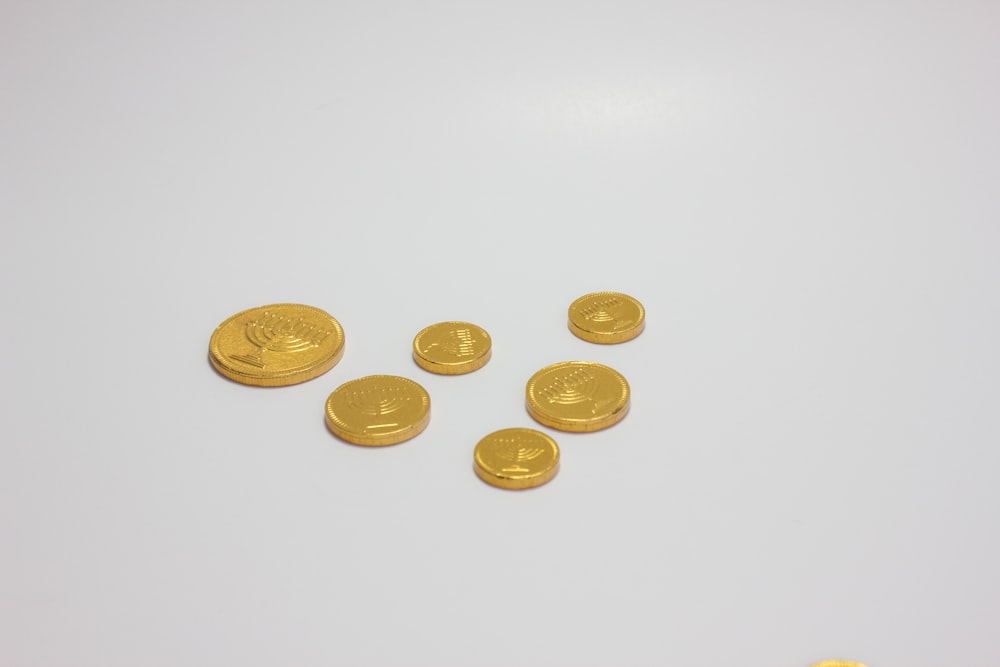 a group of gold coins sitting on top of a white table