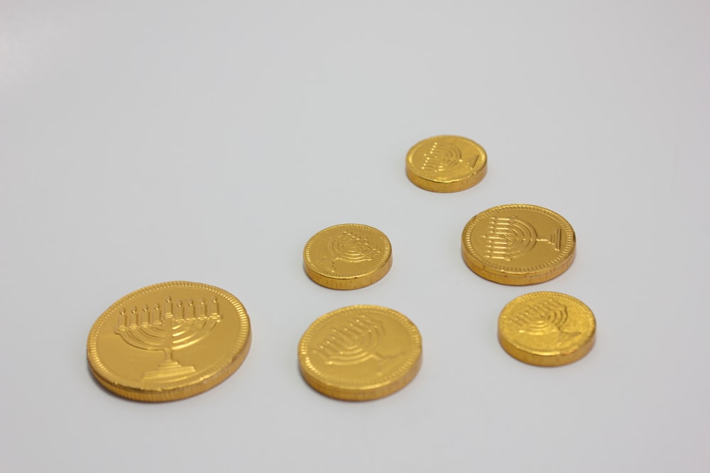 a group of gold coins sitting on top of a white table