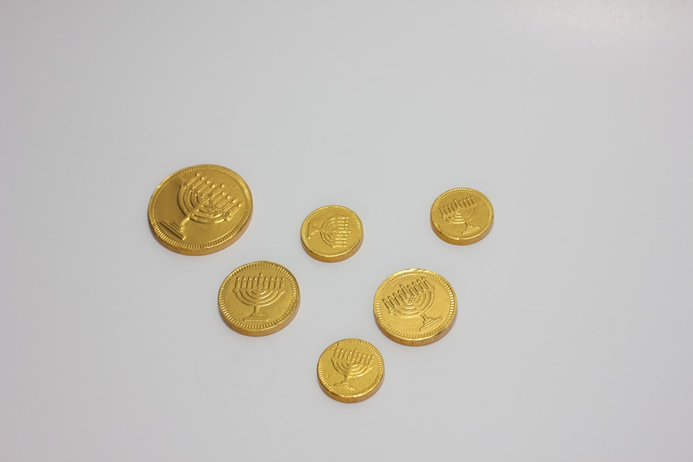 a group of gold coins sitting on top of a white table