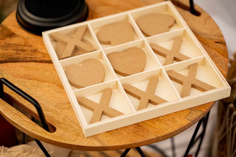 a wooden table topped with a tray of cut out shapes