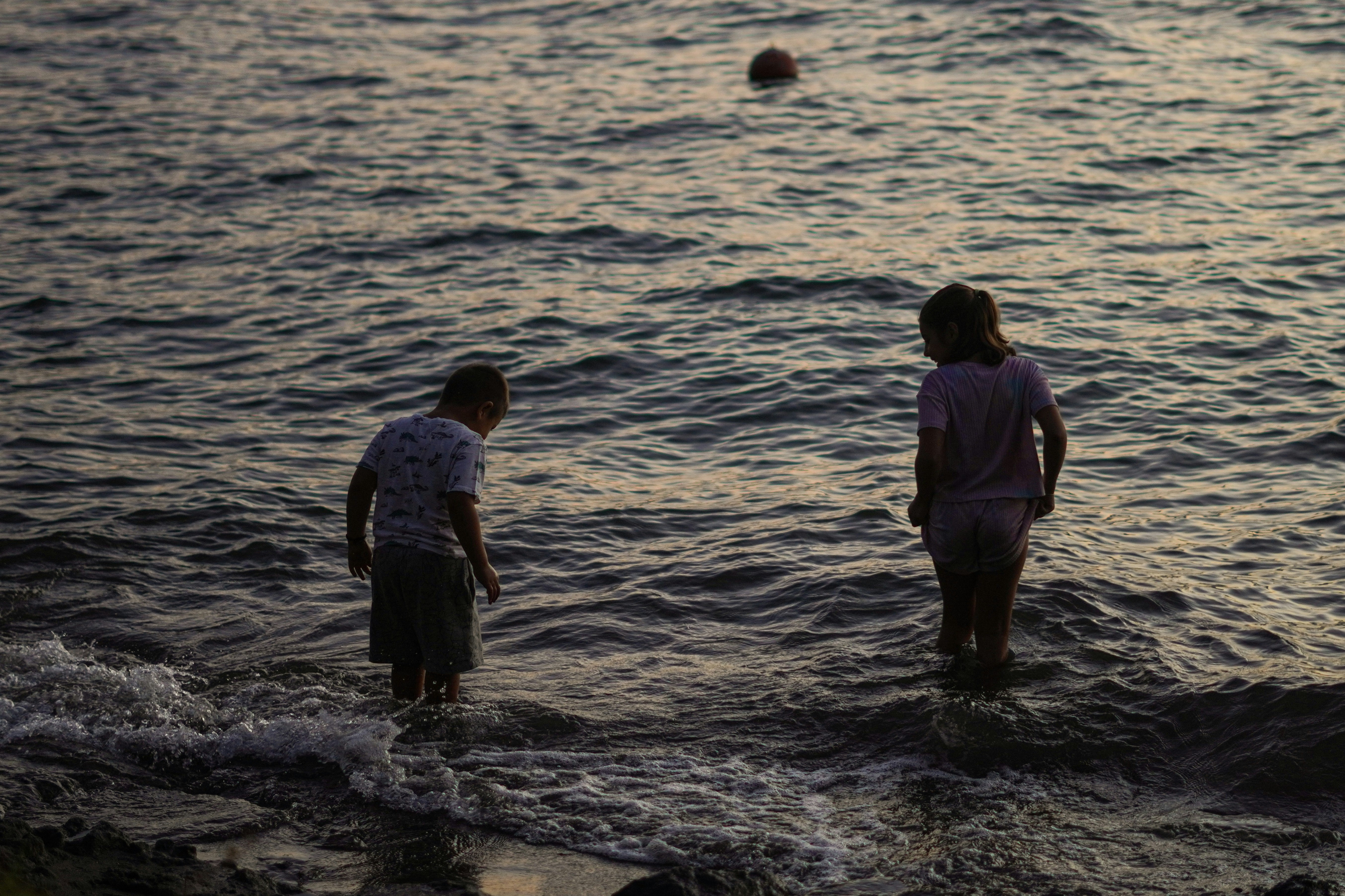 a couple of people that are standing in the water
