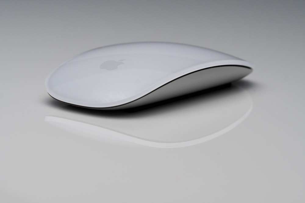 um rato de maçã branco sentado em cima de uma mesa