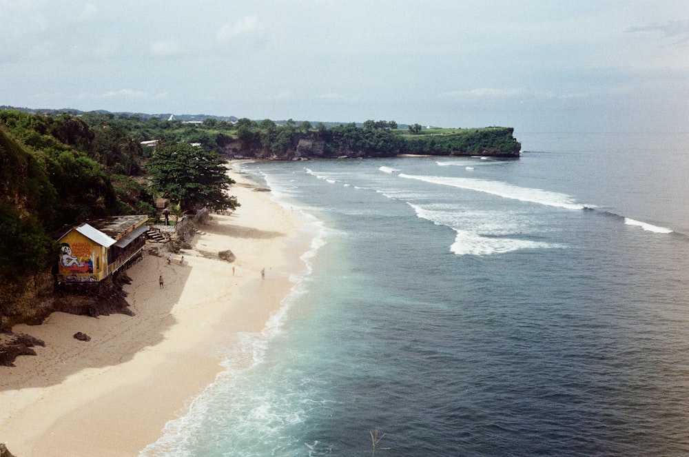 an aerial view of a beach with a boat in the water