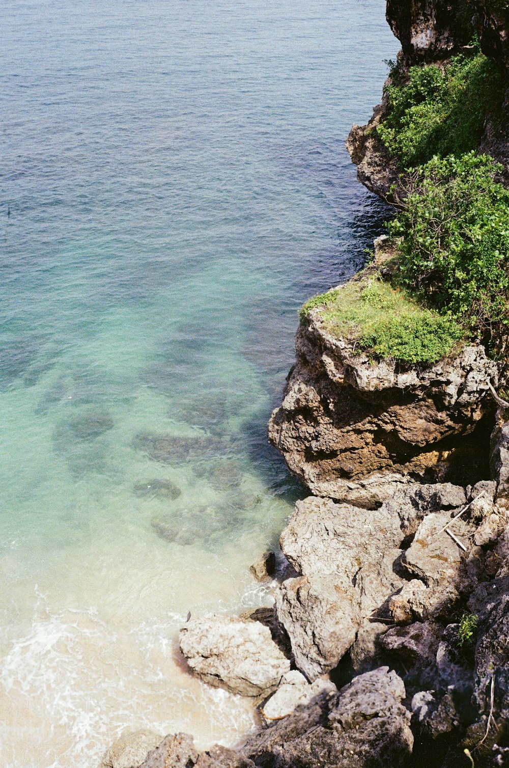 a body of water sitting next to a rocky cliff