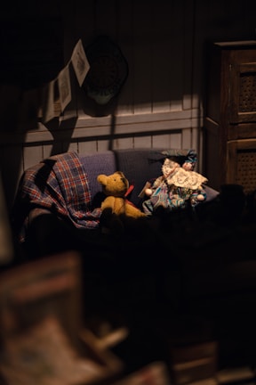 a teddy bear sitting on a couch in a dark room