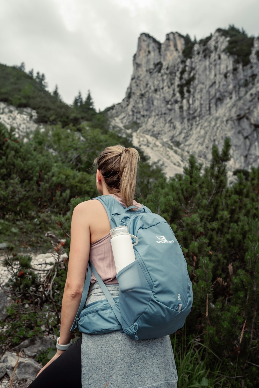 a woman with a blue backpack and a cup of coffee