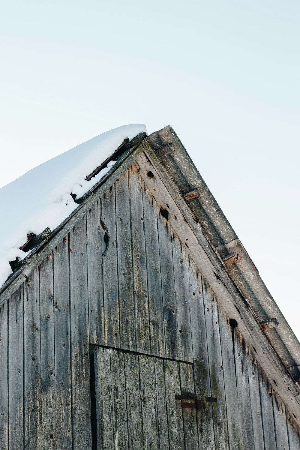 a wooden building with snow on top of it