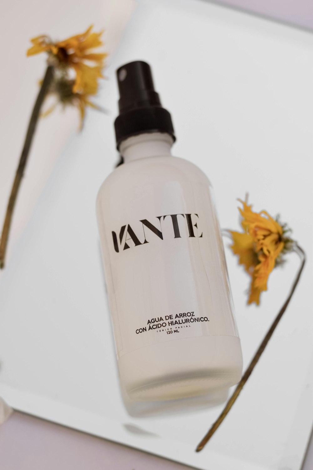 a bottle of tante on a table next to flowers