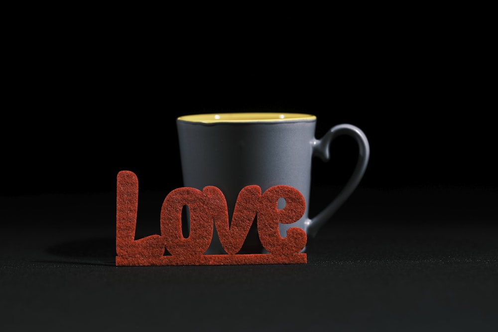 a coffee cup sitting next to the word love