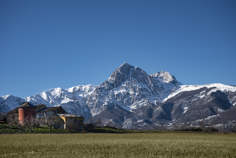 a mountain range with a barn and silo in the foreground