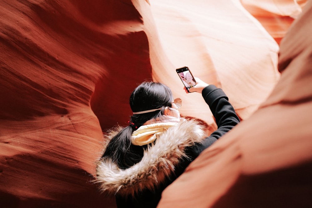 a woman taking a picture of herself in a canyon