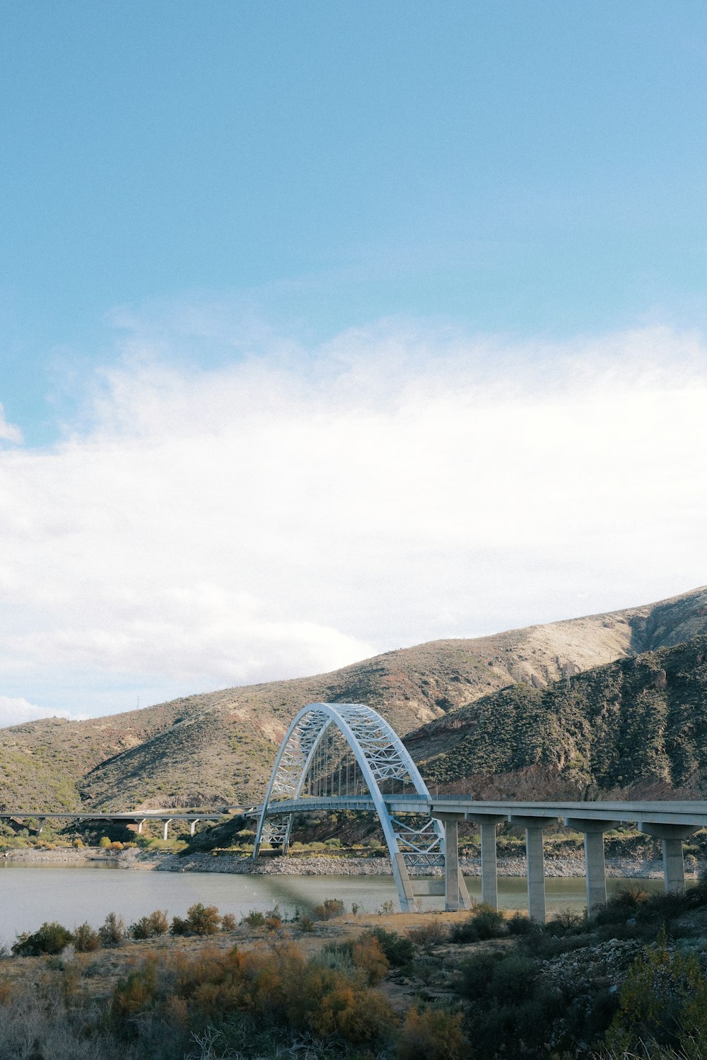 a bridge over a body of water with mountains in the background