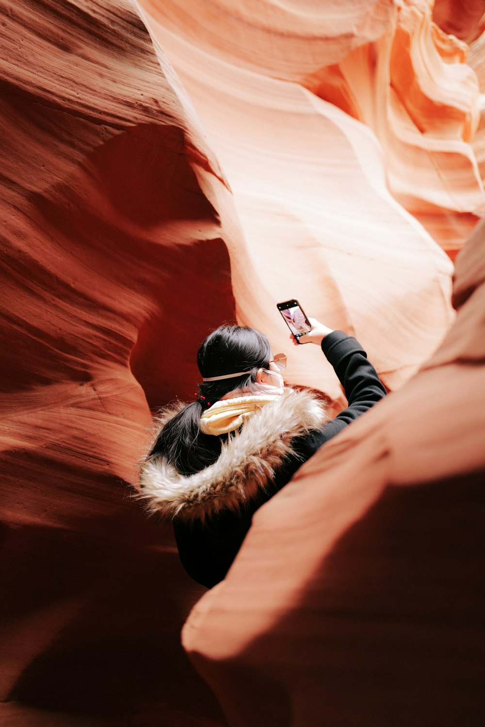 a woman taking a picture of herself in a canyon