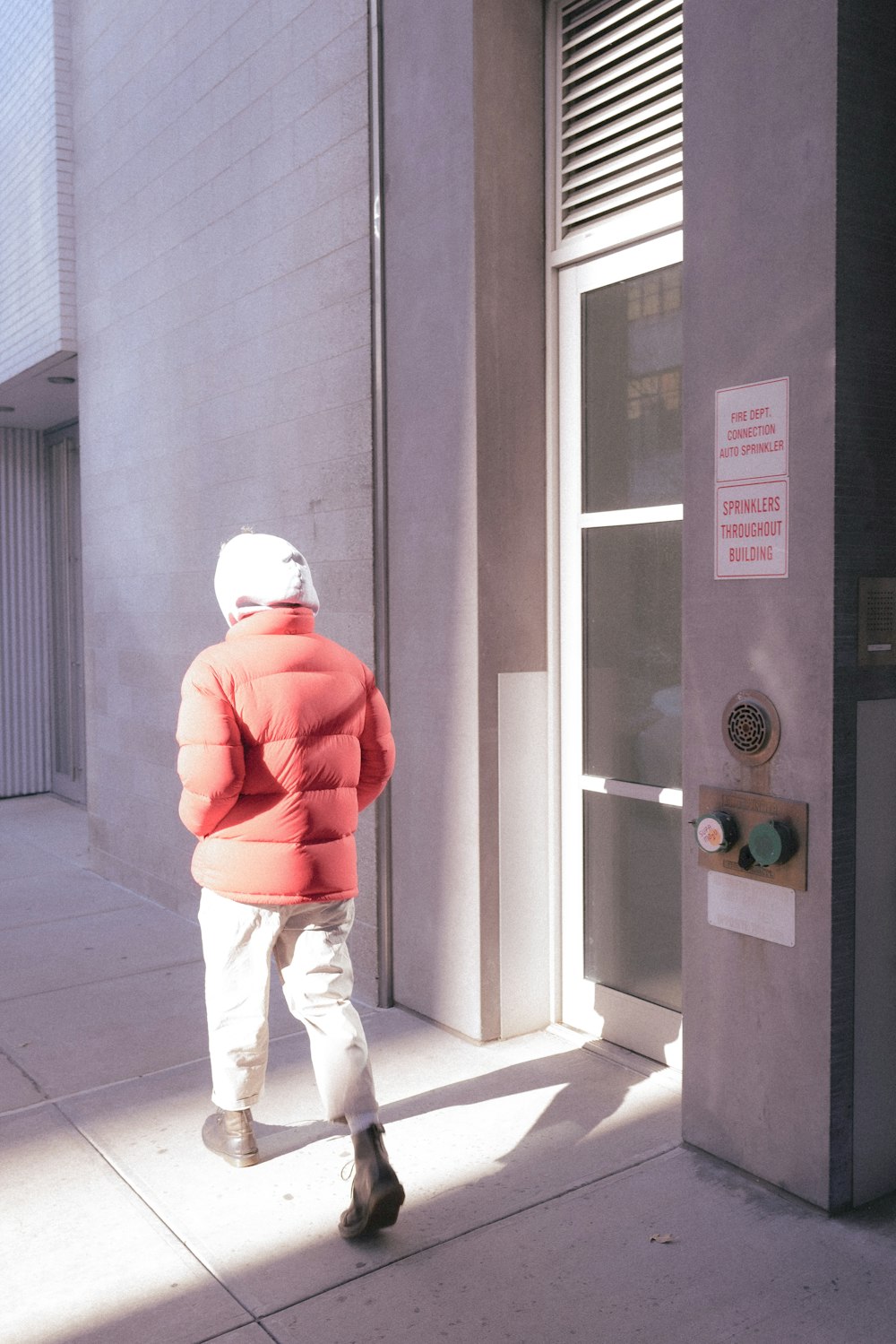 a person walking down a sidewalk near a building