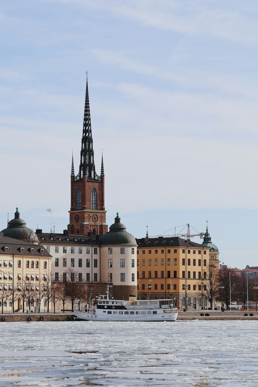 a large building with a clock tower next to a body of water