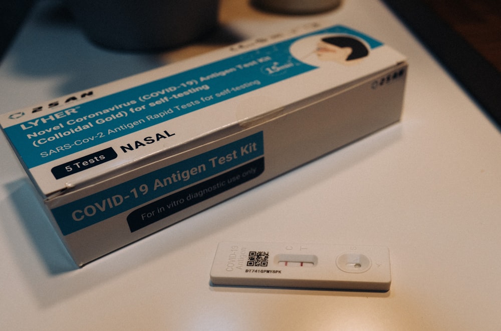 テーブルの上に座っているCOVIDD-19抗原検査キットの箱