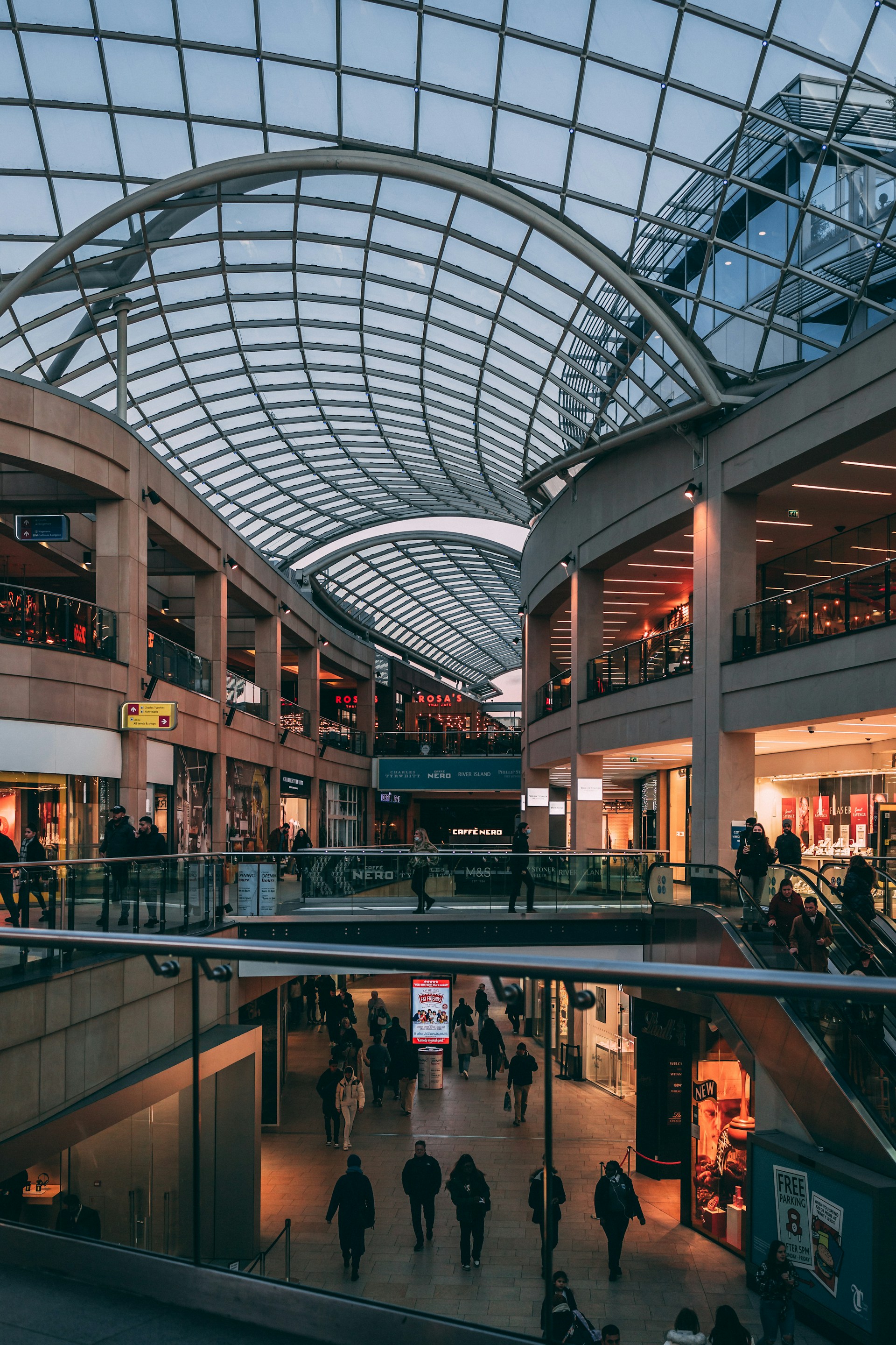 a group of people walking inside of a shopping mall