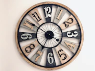 A rustic wall clock featuring a distressed wood finish and bold black numerals.