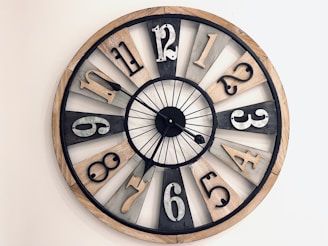 A rustic wooden wall clock with laser-cut numbers and natural wood grain texture.