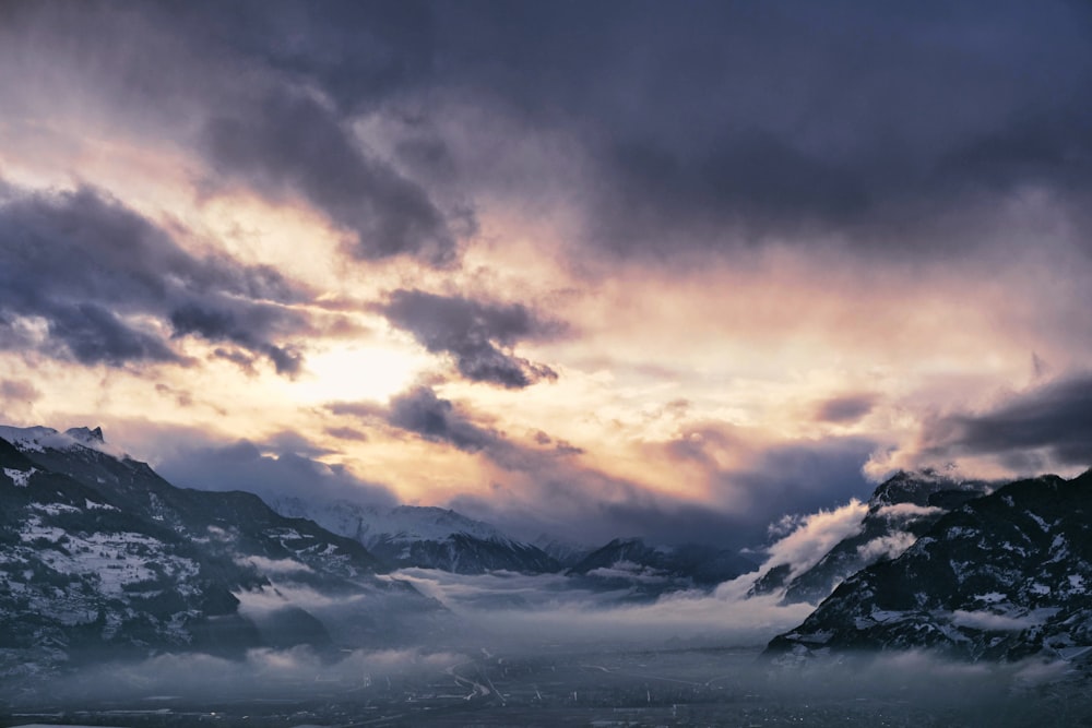 a view of a mountain range covered in clouds