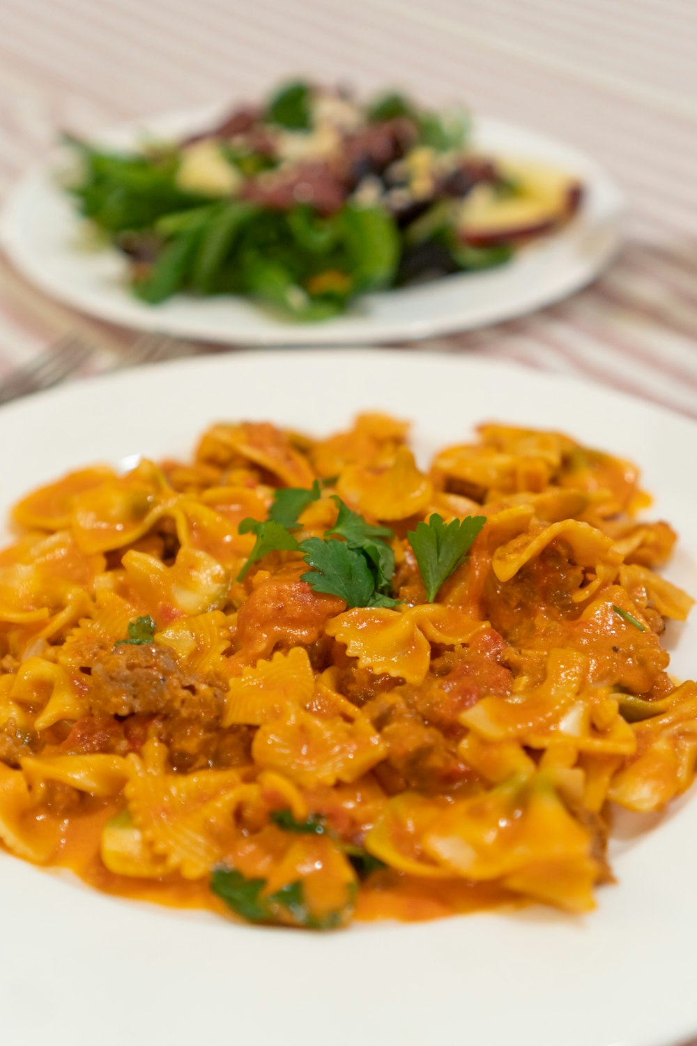 a white plate topped with pasta covered in sauce