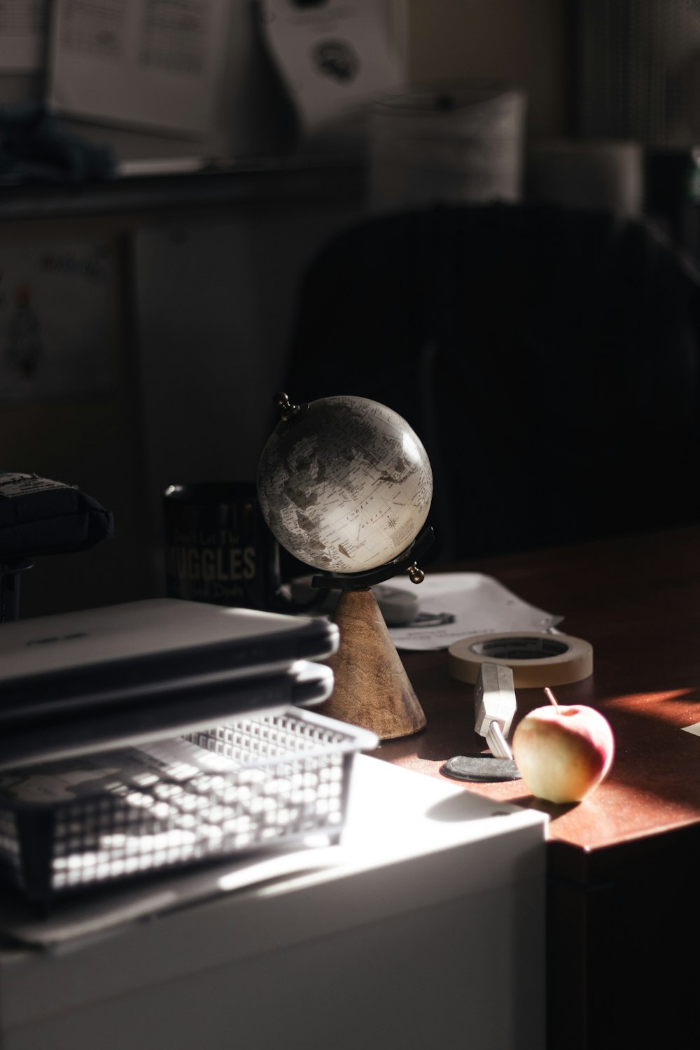 a desk with a computer and a globe on top of it