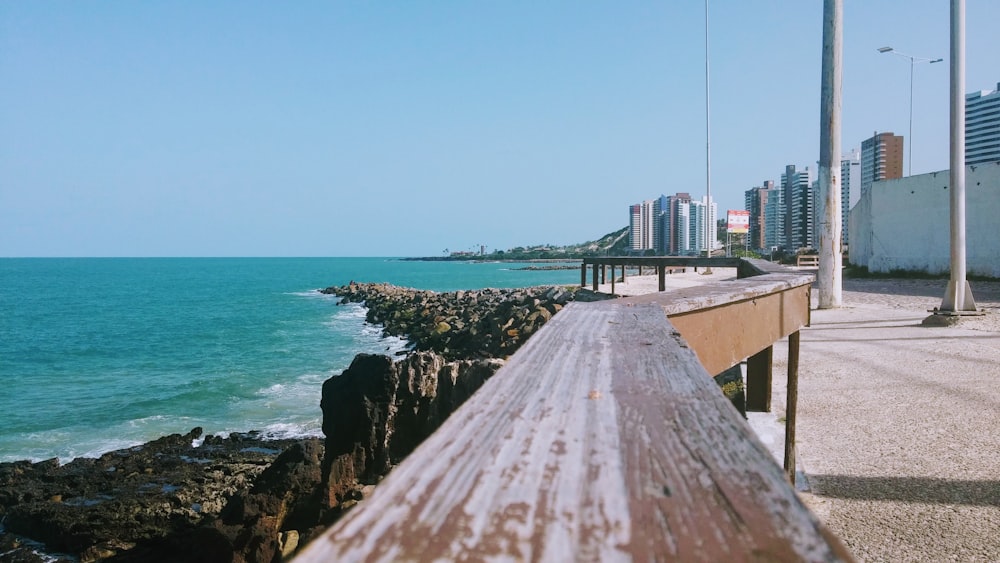 a wooden bench sitting next to the ocean