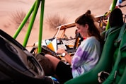 a woman sitting in a chair on top of a sandy beach