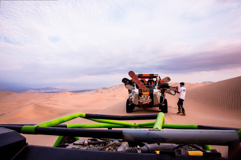 a man standing next to a truck in the desert