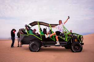 a man riding on the back of a green four wheeled vehicle